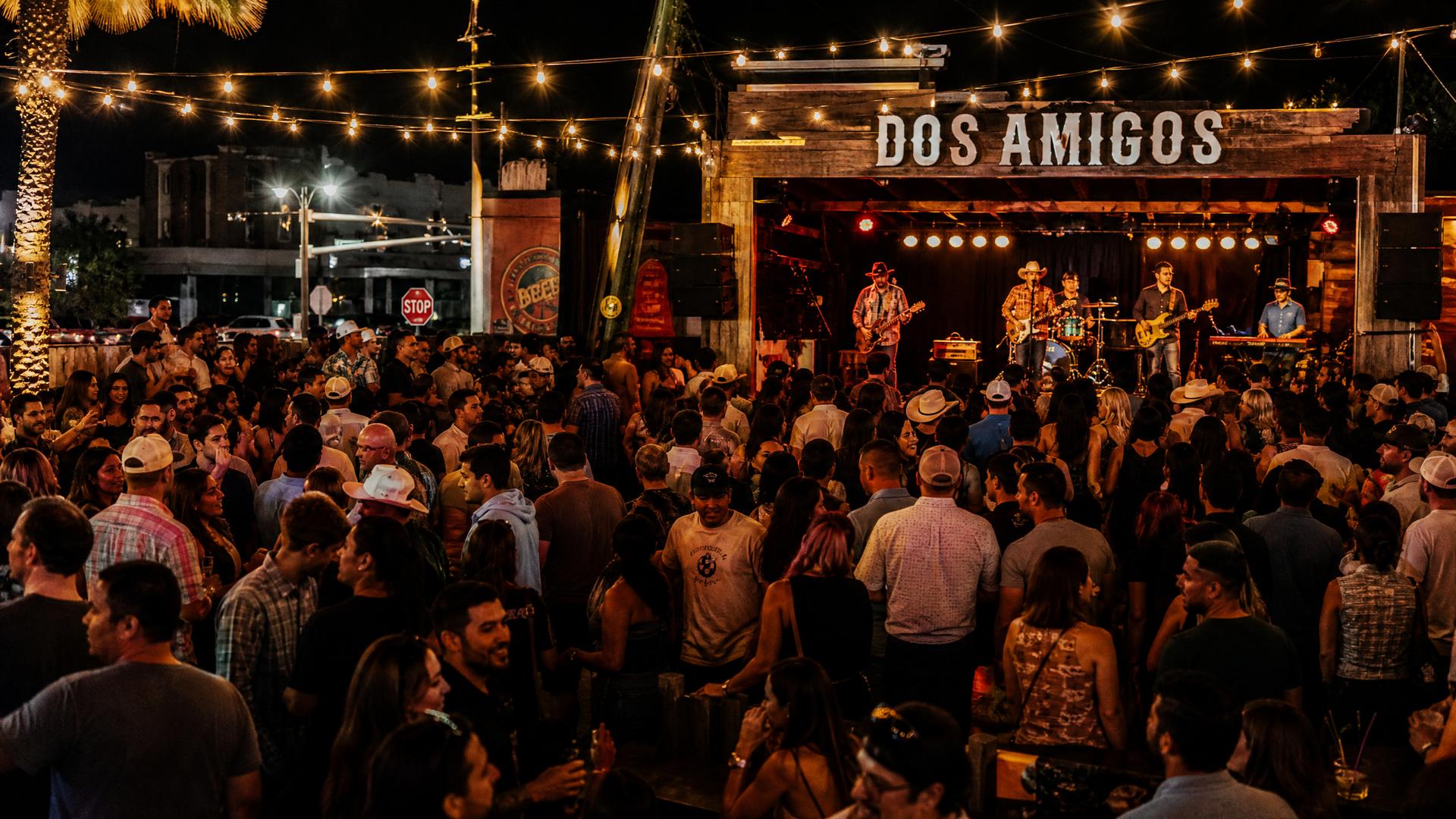 A vibrant live music venue with performers on stage and an engaged audience