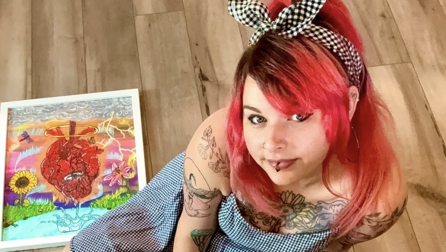 Shai Davenport, the artist behind Crafts By The Bunny, seated beside her artwork